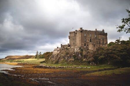 adrium Holz-Bild 50 x 30 cm: Dunvegan Castle mit einem dramatischen Himmel und seltenen Sonnenstrahlen, die alles rund um das Schloss magisch erleuchten.(131780952)