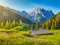 adrium Holz-Bild 40 x 30 cm: Idyllische Landschaft in den Alpen mit traditionellen Berghütten und frischen grünen Almen mit blühenden Blumen bei (80060366)