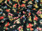 Baumwollstoff in verschiedenen Farben auf schwarzen Blumen – Meterware