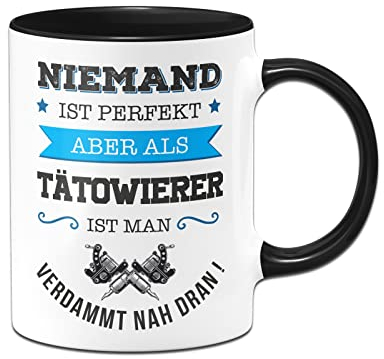 Tassenbrennerei Tasse mit Spruch Niemand ist perfekt aber als Tätowierer ist man verdammt nah dran! - Kaffeetasse Berufe lustig Geschenk (Schwarz, Tätowierer)
