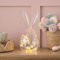 Lights4fun Glas-Osterei mit Hasenohren mit 20er LED Micro Ostereier und Küken Lichterkette warmweiß Timer Batterie Osterdeko Glasglocke Innen Tischdeko Ostern Käseglocke Glas 29 cm