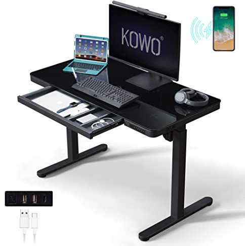 kowo Escritorio eléctrico de pie con cajones de altura superior de cristal, concentrador USB C y cargador inalámbrico, 120 cm de largo, negro, escritorio de pie para oficina con mesa de juegos de