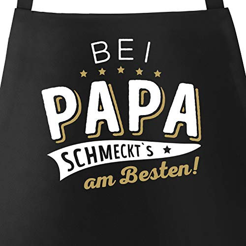 MoonWorks® Kochschürze Grill-Schürze für Männer und Frauen mit Spruch Bei Papa bzw Mama schmeckts am besten! Baumwoll-Schürze Küchenschürze schwarz unisize
