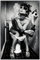 Wallario Black and White Edition - Wandbild Kloparty - Sexy Frau auf Toilette mit Zigarette und Schnaps in Premiumqualität, Poster mit schwarzem Rahmen, Größe: 61 x 91,5 cm