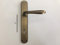 Poignée pour porte Sidney 1126 P en Maritech bronze rayé, trou Patenti, avec plaque d'entraxe 90 mm, complète pour une porte intérieure + extérieure, avec ressort de retour de vis de fixation