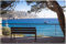 Wallario Outdoor-Poster für Garten oder Balkon Einsame Bank am Meer - Spanien im Sommer, Motivbanner Größe: ca. 120 x 180 cm, Outdoor-Bild