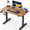 CUBICUBI Schreibtisch Höhenverstellbar Elektrisch, 110 x 60 cm Stehpult T-Beine aus Stahl mit 3-Funktions-Memory-Steuerung, Anti-kollisions System, Rollen, Schwarz Rahmen/Braun Tischplatte
