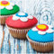 Wallario Glasbild Bunte Muffins - Alter Holztisch - Stillleben - 50 x 50 cm Wandbilder Glas in Premium-Qualität: Brillante Farben, freischwebende Optik