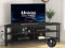 Unikito Eck-TV-Ständer mit Steckdose, Eck-TV-Tisch mit 4 offenen Fächern, TV-Schrank, Holz, TV-Ständer für Wohnzimmer, Schlafzimmer, Eck-TV-Ständer für 139,7 cm (55 Zoll) Fernseher, Schwarz
