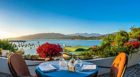 Leinwand-Bild 150 x 80 cm: Romantisches Dinnerlokal mit idyllischem Panoramablick auf die mediterrane Küstenlandschaft bei Sonnenuntergang im goldenen Aben(47392223)